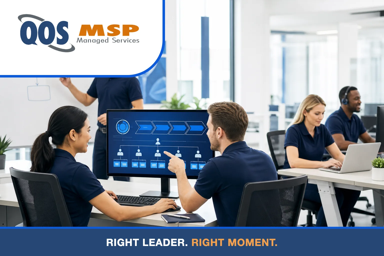 IT professionals in navy polos planning a technology roadmap around a monitor in a modern office